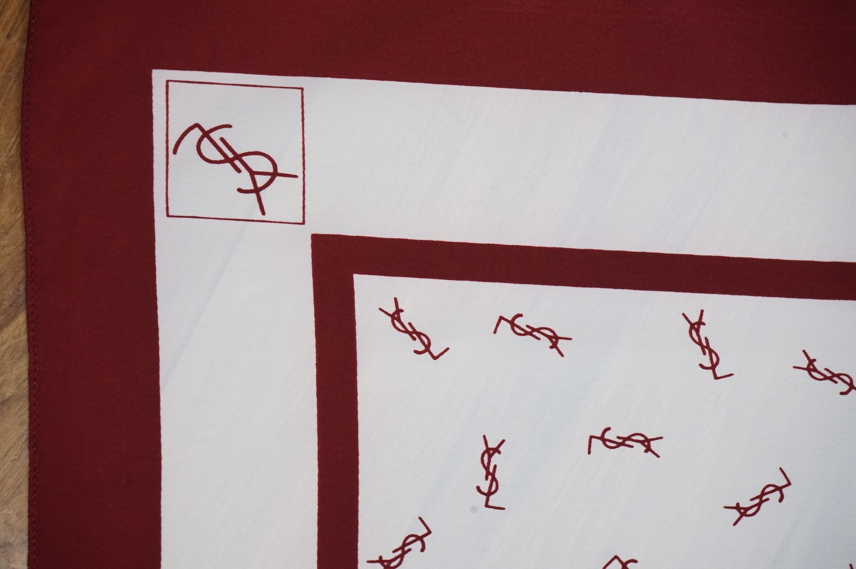 Two Yves Saint Laurent silk scarves comprising a monogrammed example and a patterned brown example with Foulards folding case